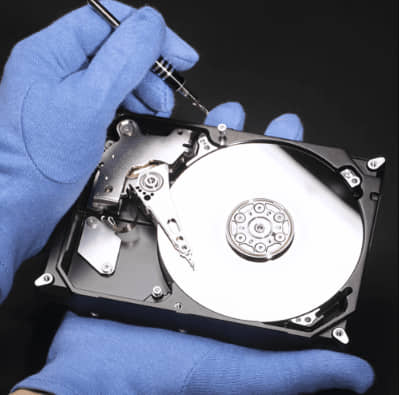 Technician handling internal hard drive components for secure data destruction and shredding service at eRevival